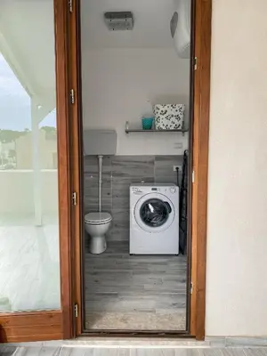 a bathroom with a washing machine and a toilet at A Cantunera in San Vito lo Capo