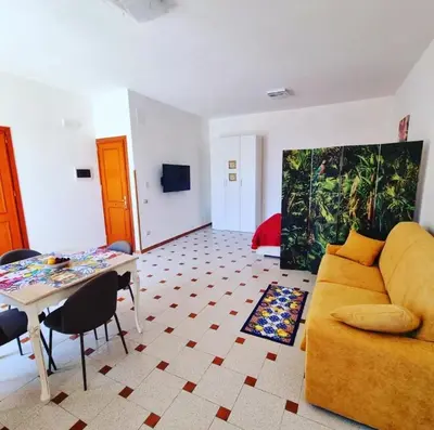 a living room with a yellow couch and a table at casaafauka in Carini