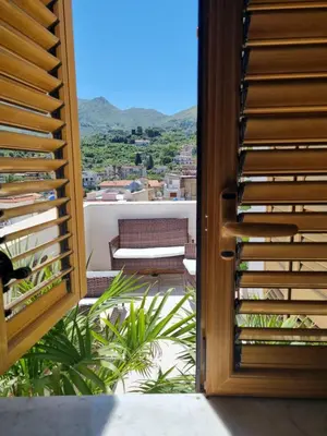 a door to a balcony with a view of a couch at casaafauka in Carini