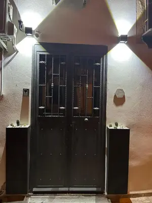 a black door in the side of a building with lights at Casa Elivì Ballaró 2 passi dal centro storico, parcheggio e stazione ferroviaria in Palermo