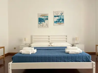 a bedroom with a large bed with blue sheets and pillows at Casavacanze nel blu Maestrale in Isola delle Femmine