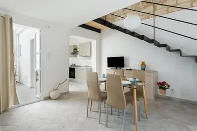 a kitchen and dining room with a table and chairs at RYS Mondello House in Palermo