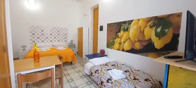 a room with two beds and a painting on the wall at Casetta Colorata in Bagheria