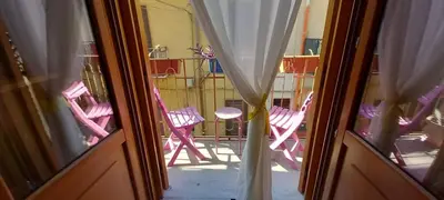 a view of a room with pink chairs through a window at Casetta Colorata in Bagheria