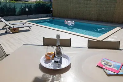 a table with two glasses and a bottle of wine at Villa Giada - Private pool in Campofelice di Roccella