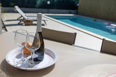 a bottle of wine on a plate with two glasses at Villa Giada - Private pool in Campofelice di Roccella