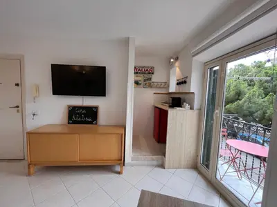 a living room with a tv and a sliding glass door at Casa Khalesia in Palermo