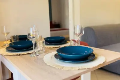 a table with blue plates and wine glasses on it at Casa Khalesia in Palermo