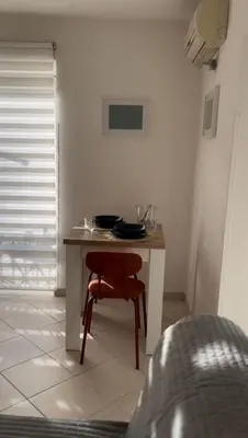 a small table with a red chair in a room at Casa Khalesia in Palermo