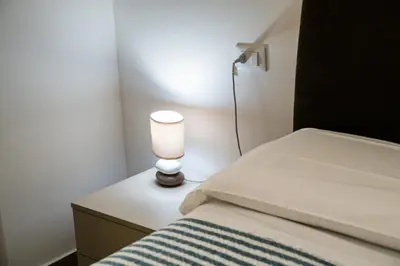 a lamp sitting on a table next to a bed at Villa Capri - Private pool in Campofelice di Roccella