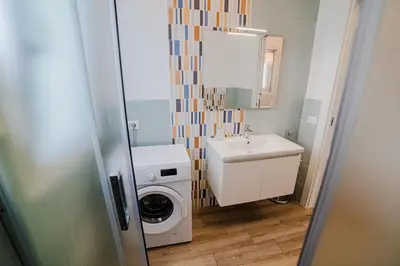 a bathroom with a washing machine and a sink at Villa Capri - Private pool in Campofelice di Roccella
