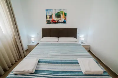 a bedroom with a large bed with two night stands at Villa Capri - Private pool in Campofelice di Roccella