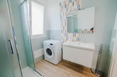 a bathroom with a washing machine and a sink at Villa Capri - Private pool in Campofelice di Roccella