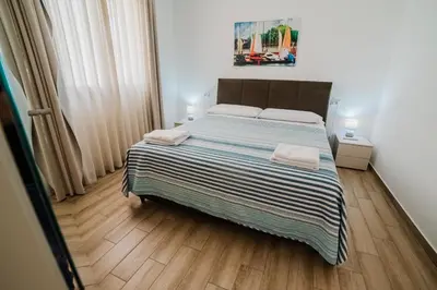 a bedroom with a large bed with a striped blanket at Villa Capri - Private pool in Campofelice di Roccella