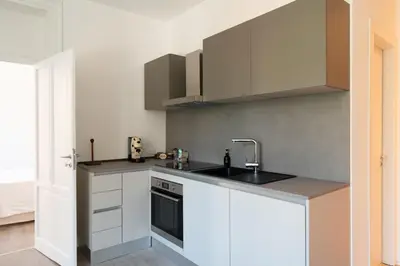 a kitchen with white cabinets and a sink at Dimora Florio in Palermo
