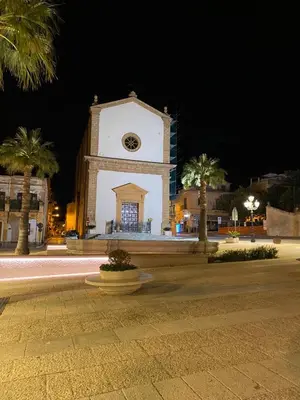 a building with a clock tower at night at Casa Ciccio in Cinisi