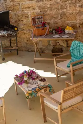 a room with chairs and a table with flowers on it at La mia deliziosa Casetta di giù in Termini Imerese