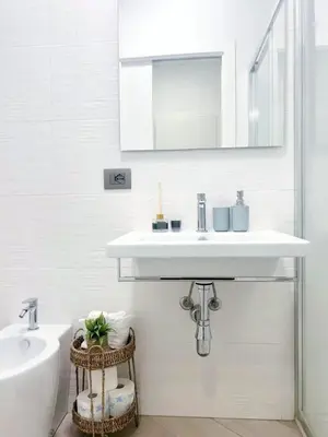 a white bathroom with a sink and a mirror at Casa Marinaro in Castellammare del Golfo