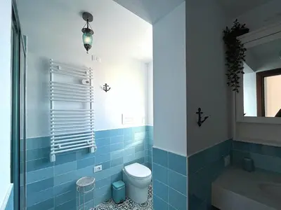 a blue bathroom with a toilet and a sink at Solemar Sicilia - Casa Tramonto in Bagheria