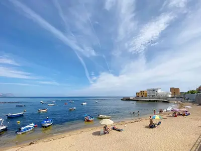 a group of people on a beach with boats in the water at Solemar Sicilia - Casa Tramonto in Bagheria