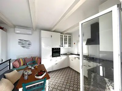 a living room with a table and a kitchen at Solemar Sicilia - Casa Tramonto in Bagheria