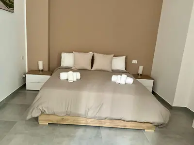 a bedroom with a large bed with three pillows at HOLIDAY HOUSE ORLANDO in Palermo