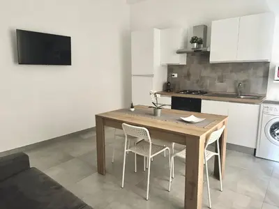 a kitchen with a wooden table and chairs in a room at HOLIDAY HOUSE ORLANDO in Palermo