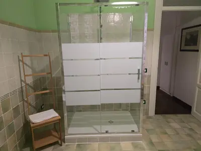 a shower with a glass door in a bathroom at Stabile 16 Apartment in Palermo