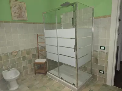 a bathroom with a glass shower and a toilet at Stabile 16 Apartment in Palermo