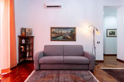 a living room with a couch and a painting on the wall at Stabile 16 Apartment in Palermo