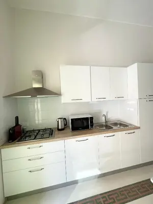 a white kitchen with a sink and a microwave at Conte125 in Cinisi