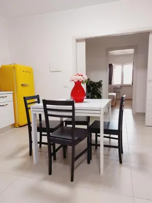 a white table with black chairs and a vase with flowers at Un Passo dal Porto in Palermo