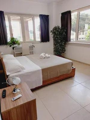 a bedroom with a bed and a table and windows at Un Passo dal Porto in Palermo