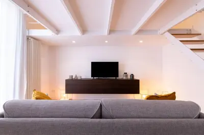 a living room with a couch and a flat screen tv at Oliveri Vintage House at Politeama in Palermo