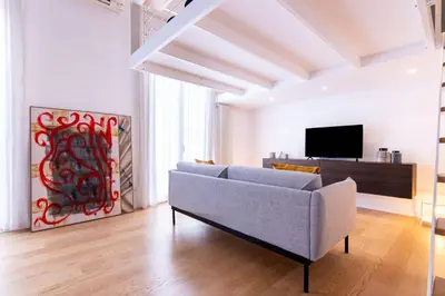 a living room with a couch and a tv at Oliveri Vintage House at Politeama in Palermo