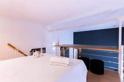 a bedroom with a white bed with two towels on it at Oliveri Vintage House at Politeama in Palermo