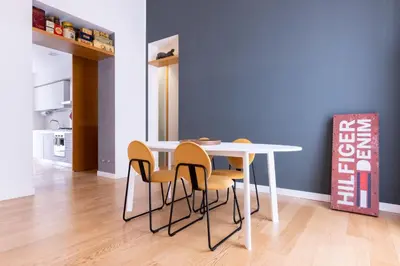 a dining room table with yellow chairs and a white table at Oliveri Vintage House at Politeama in Palermo