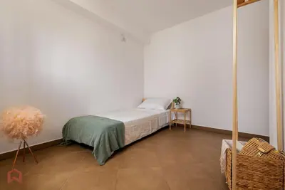 a bedroom with a bed in a white room at Posh villa with pool & jacuzzi in Balestrate