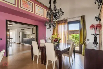 a dining room with a table and white chairs at Posh villa with pool & jacuzzi in Balestrate
