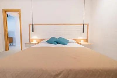 a bedroom with a large bed with two blue pillows at Mondello 2C casa vacanze in Palermo