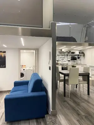 a living room with a blue couch and a table at Life Rooms in Misilmeri
