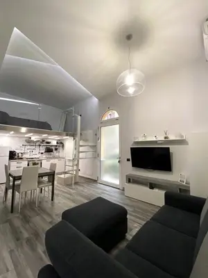 a living room with a couch and a dining room at Life Rooms in Misilmeri