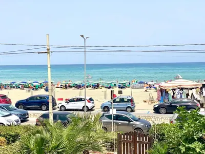 a parking lot at the beach with cars parked at Casa Perla Marina sul mare in Castellammare del Golfo