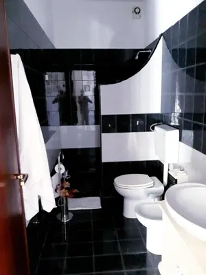a black and white bathroom with a toilet and a sink at Casa vacanze zina in Altavilla Milicia