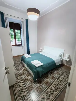a white room with a bed and a window at Thalia in Palermo
