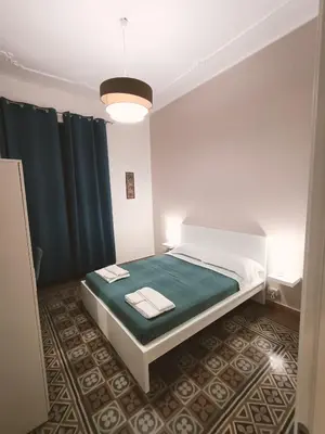 a bedroom with a bed with a green and white mattress at Thalia in Palermo