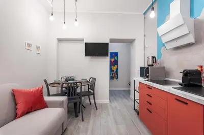 a kitchen and living room with a couch and a table at LE PORTE DEL KASSARO in Palermo