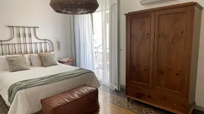 a bedroom with a large bed and a wooden cabinet at Shallah Apartment nel cuore del centro storico di Palermo in Palermo