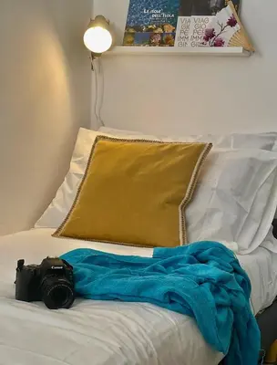 a camera laying on a bed with a blanket at Shallah Apartment nel cuore del centro storico di Palermo in Palermo