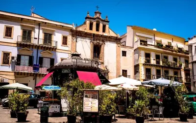 a group of buildings with umbrellas in a street at Shallah Apartment nel cuore del centro storico di Palermo in Palermo